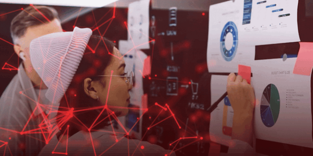 A woman in a beanie analyzes charts on a wall, with red network graphics overlaying the scene, conveying focus and collaboration in a tech setting.