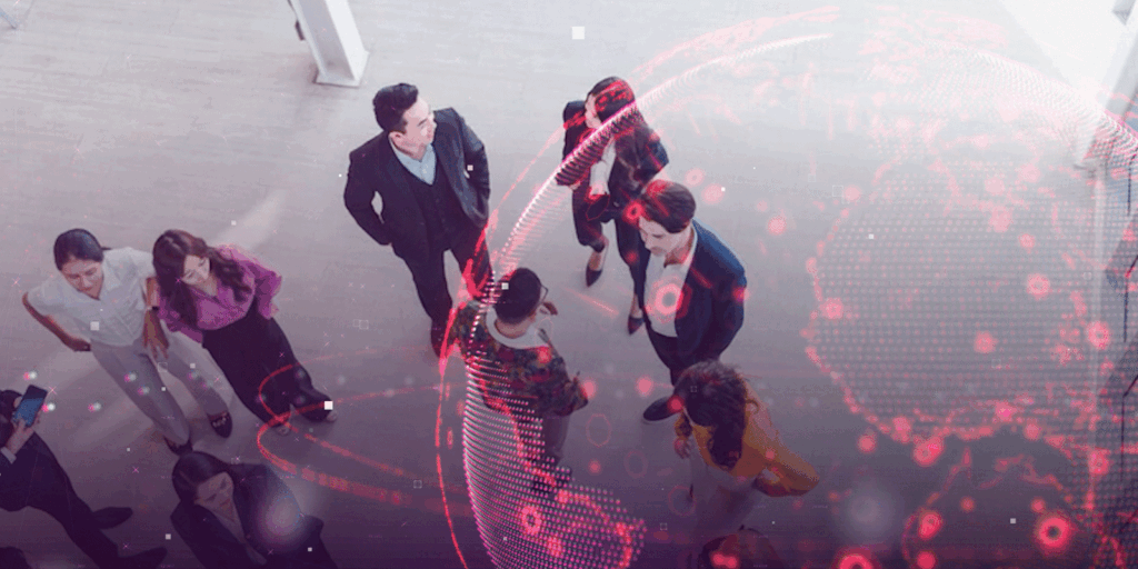 Overhead view of a diverse group of professionals in conversation, overlaid with a digital world map in red, symbolizing global networking.